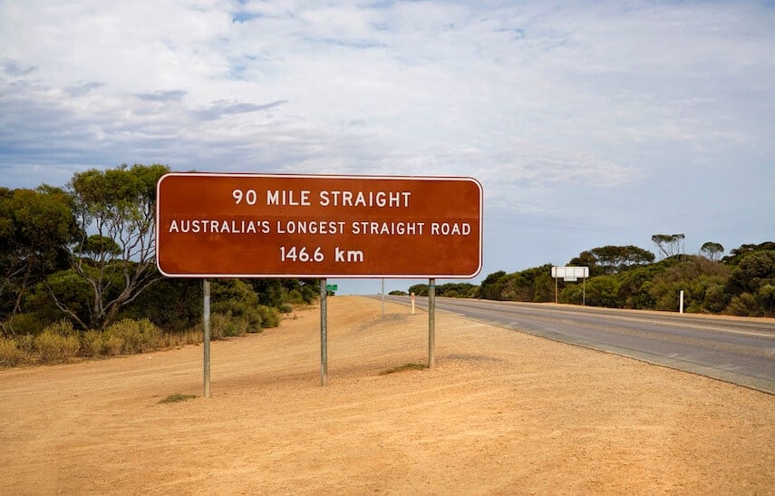 Sign for Australia's Longest Straight Road next to the road