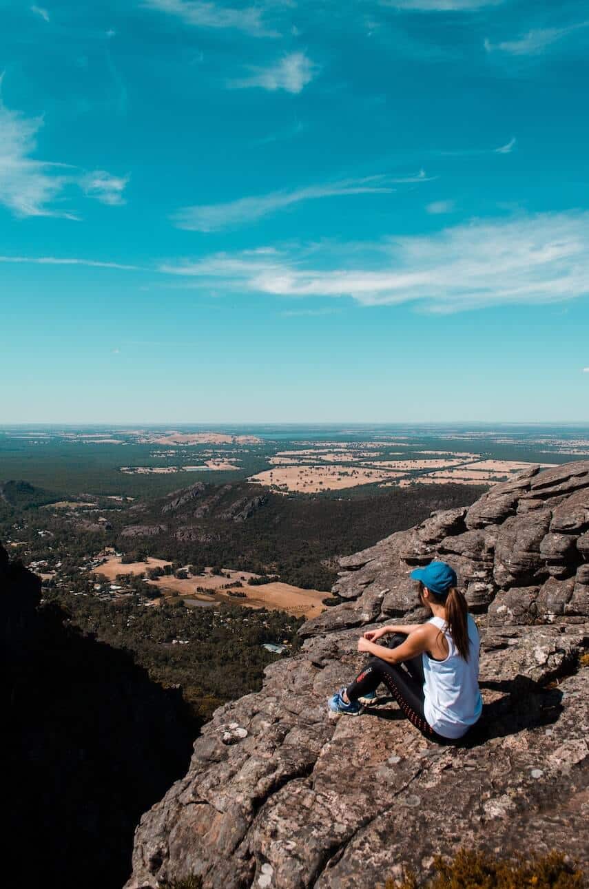 Woman sitting on a rock looking out over Grampians National Park