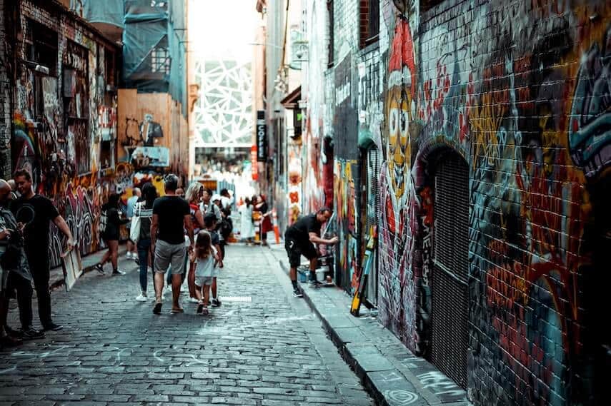 A Melbourne Laneway with cobbled street and street art covering the walls either side