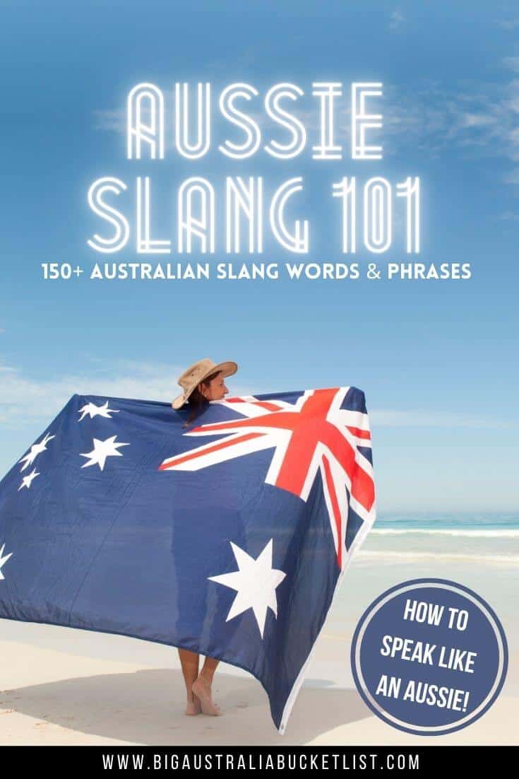 Aussie Slang 101 - 150+ Australian Slang Words & Phrases (featuring a woman holding an Australian flag outstretched hbehind her on the beach wearing a stetson, with the title text overlay above her)