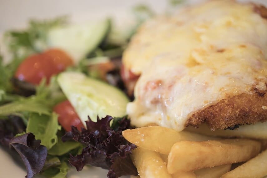 Chicken Parmigiana - chicken snitzel topped with melted cheese with chips and salad