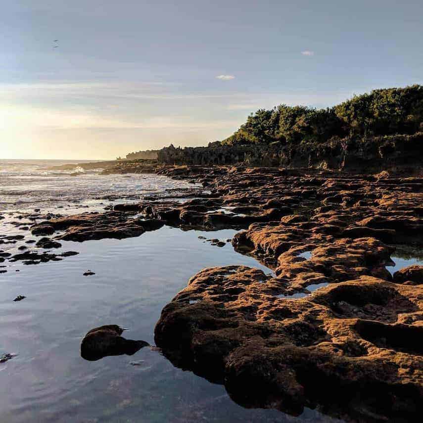 Rock pools leading out to the ocean at Lily Beach on Christmas Island at sunrise
