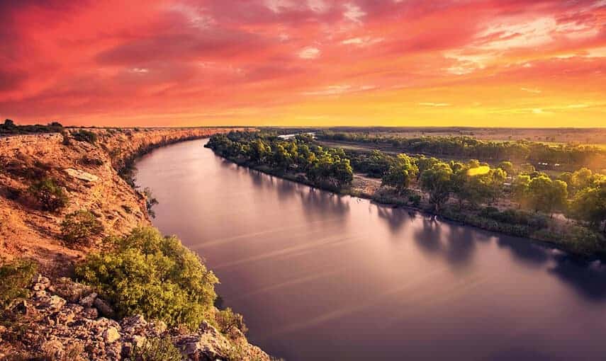 Incredible sunset on the Murray River, the left bank is rocky, the right bank is lined with green trees