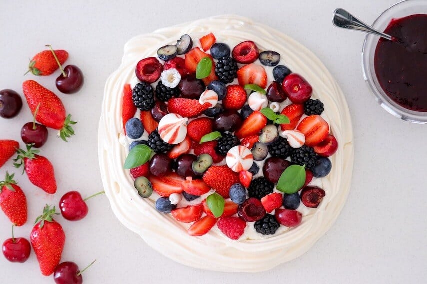 Top down shot of a pavlova covered in mixed berries