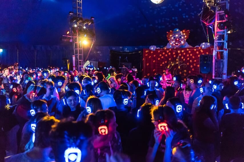 Silent disco at Mooba festival at night with headphones lit up