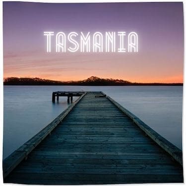 Link Tile to Tasmania Category - image of a wooden pier over the ocean with land in the distance under a purple and pink sunset sky