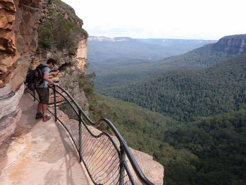Wentworth Falls loop hiking trail with man looking over the ballustrade edge into the canyon below