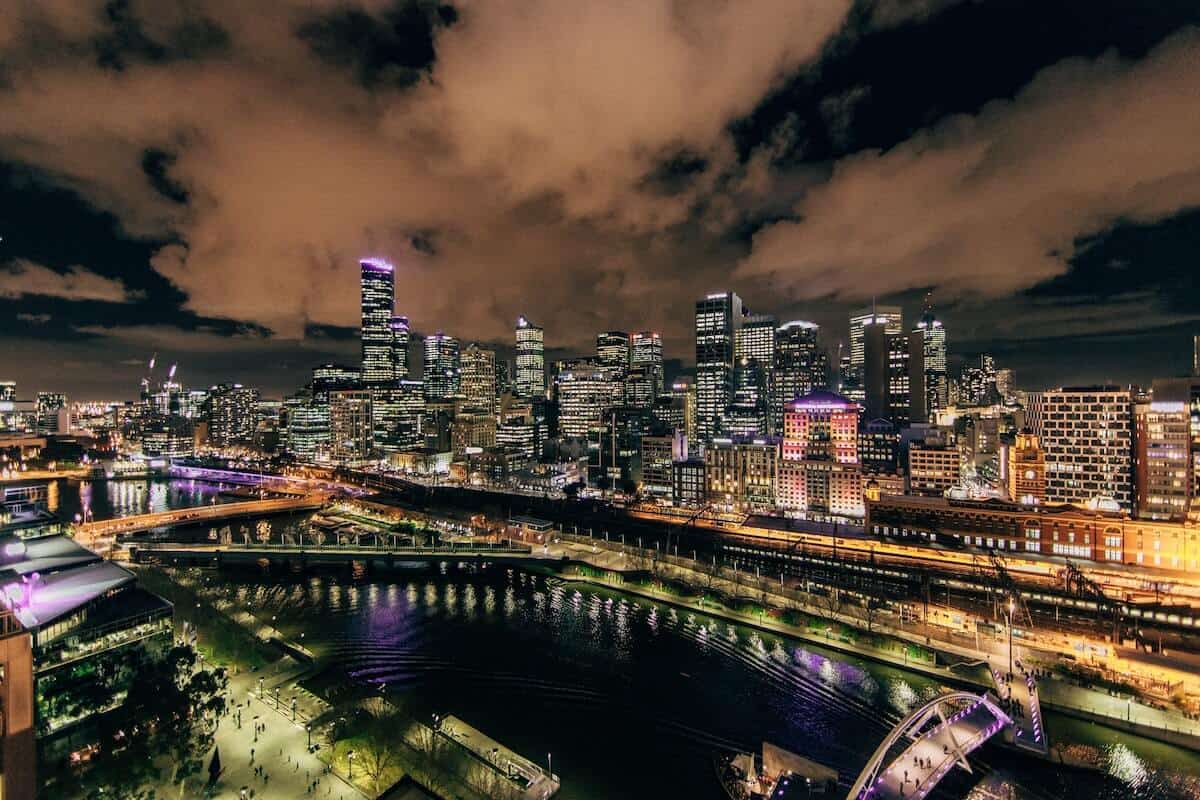 Best Time to Visit Melbourne Australia cover image of the city skyline lit up at night along the Yarra river