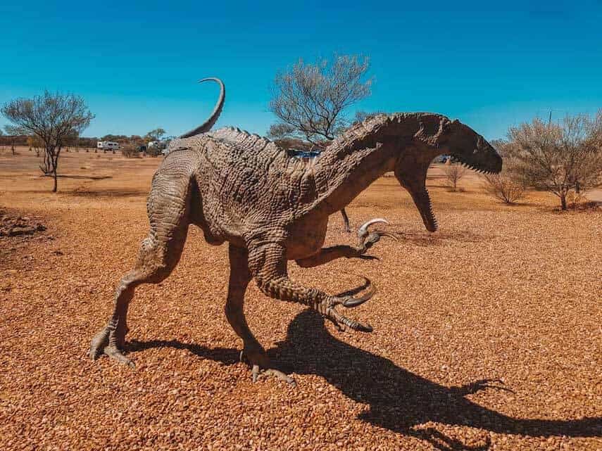 Statue of a Velociraptor Dinosaur in the red earth of Outback Queensland