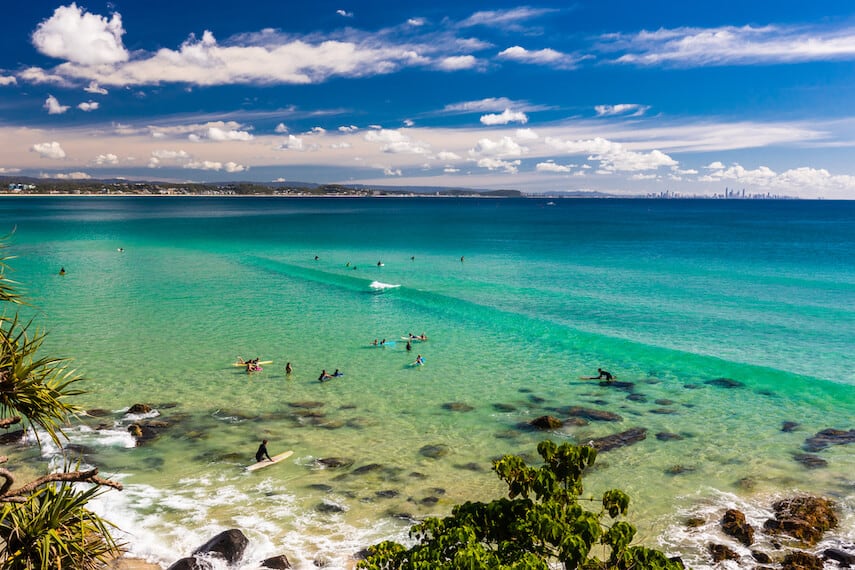 Rainbow Bay - sheltered cove with turquoise blue waters, people swimming