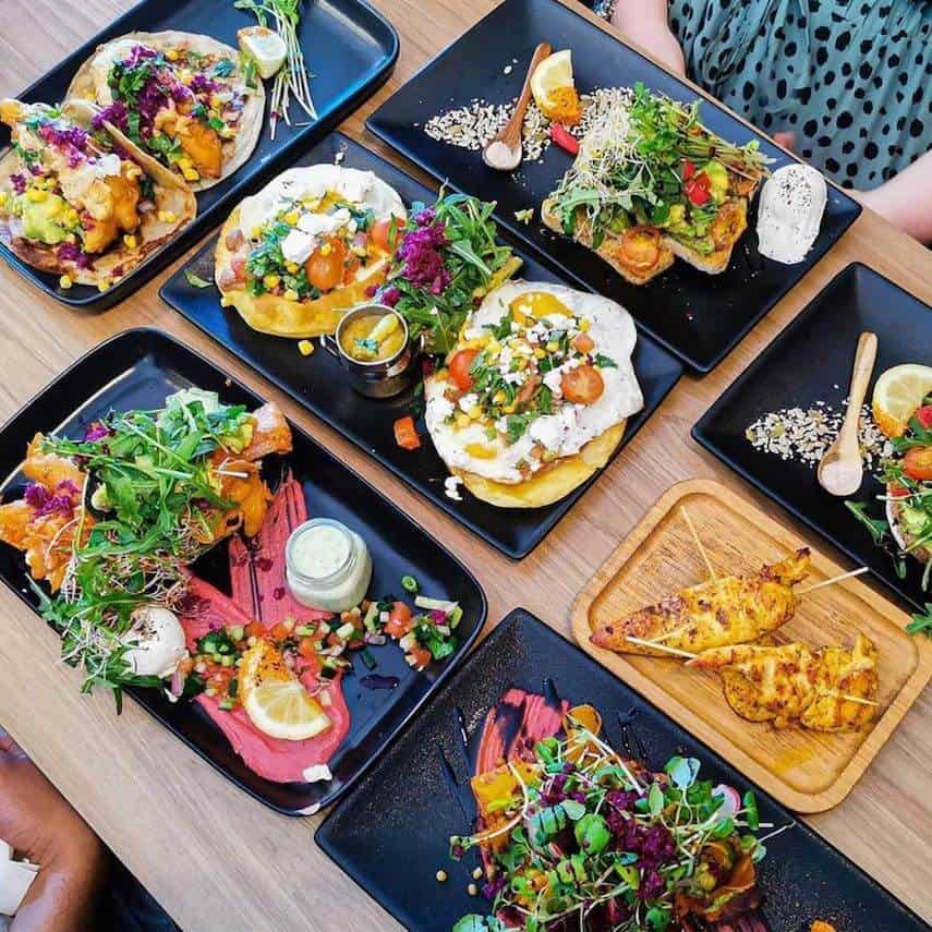 Top down shot of multiple different dishes presented on black rectangular plates