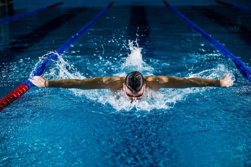 Man swimming butterfly towards the camera, arms outstretched