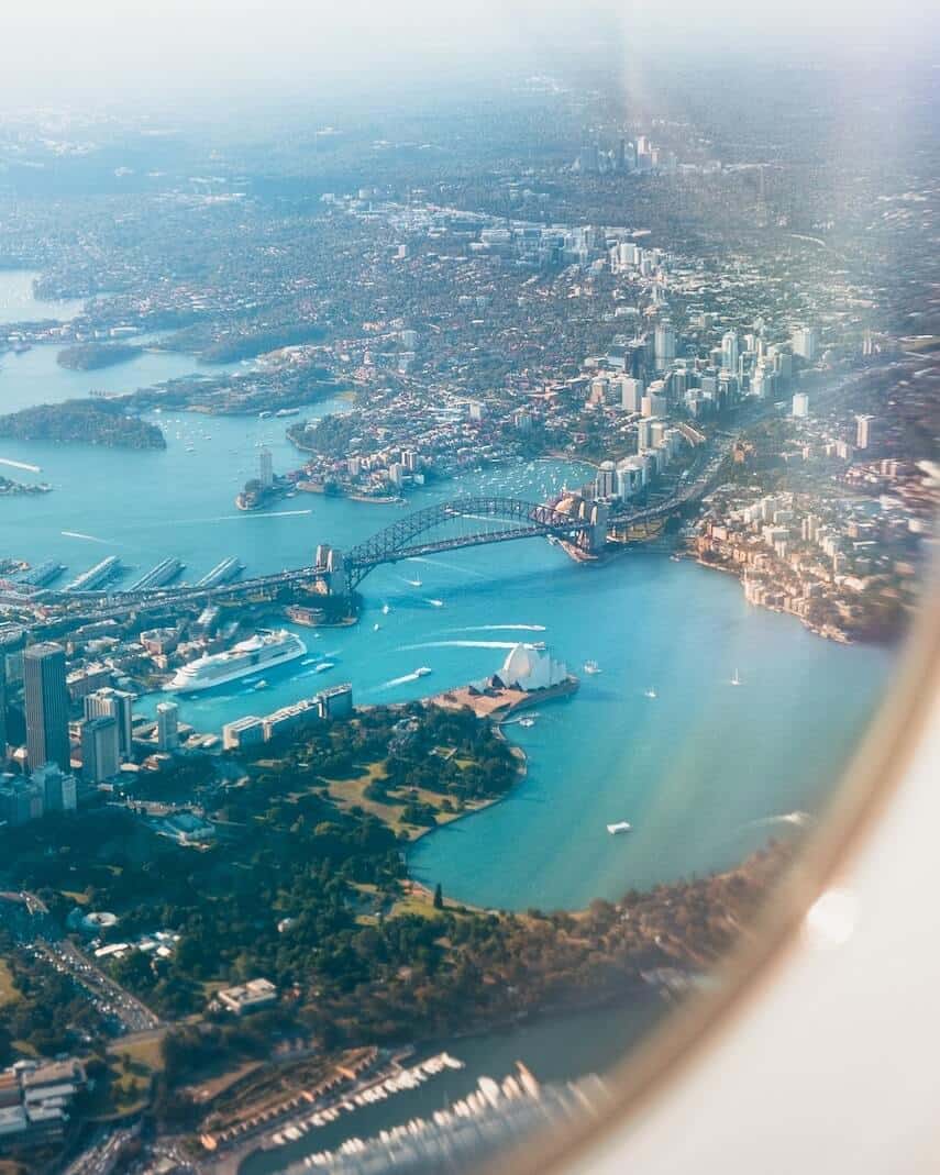 Sydney Opera House and Sydney Harbour Bridge as seen from an airplane window